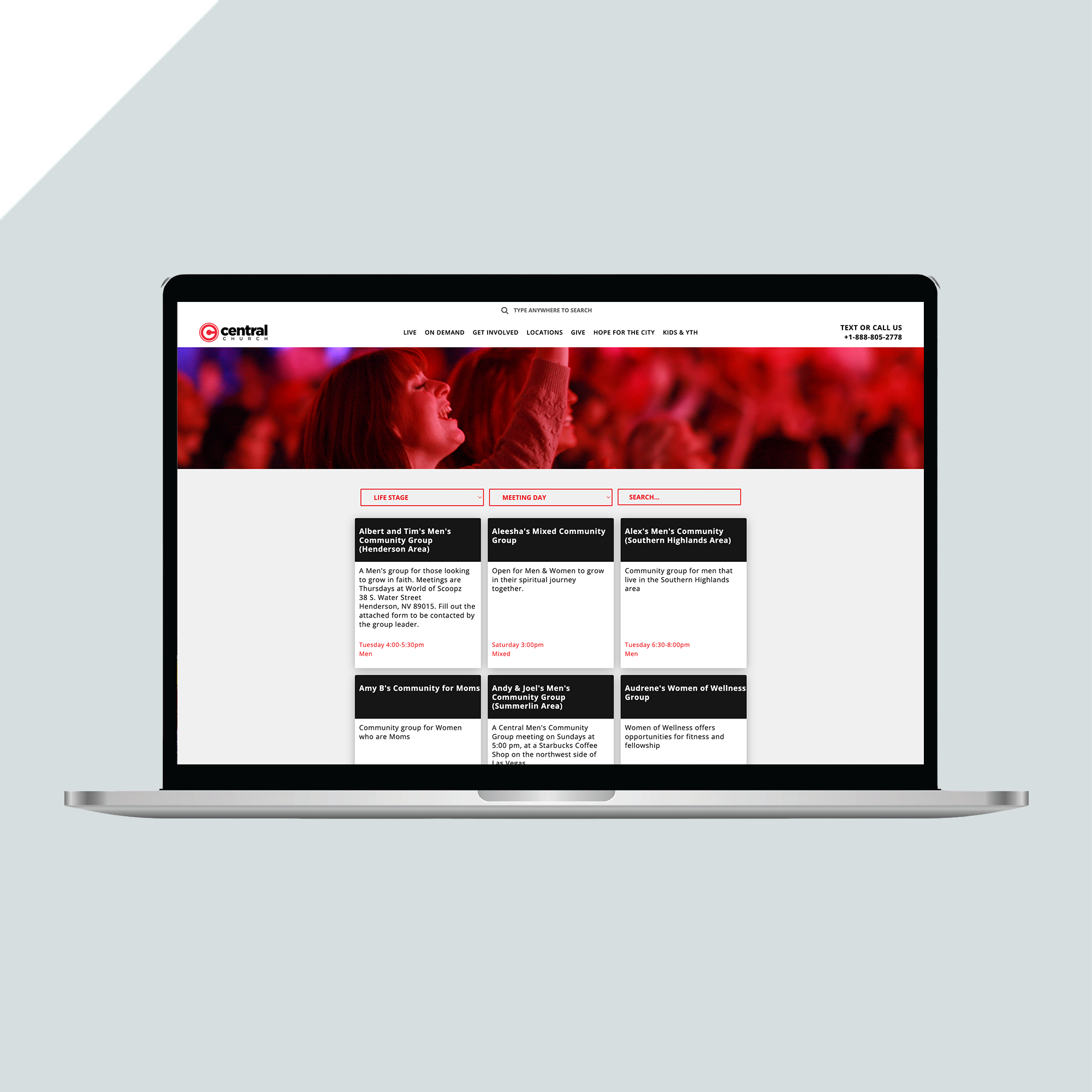 A laptop displaying a website with a red and white header, navigation menu, and a grid layout with event listings against a blurred background of people at a concert. A laptop displaying a website with a red and white header, navigation menu, and a grid layout with event listings against a blurred background of people at a concert.